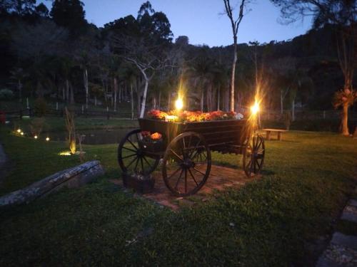 a wooden cart with flowers in a park at night at Refugio Poço do Cânion in Barracão