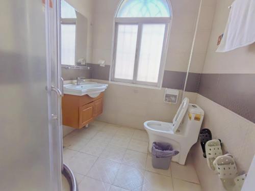 a bathroom with a sink and a toilet and a window at 厦门哈哈虎客栈 in Xiamen