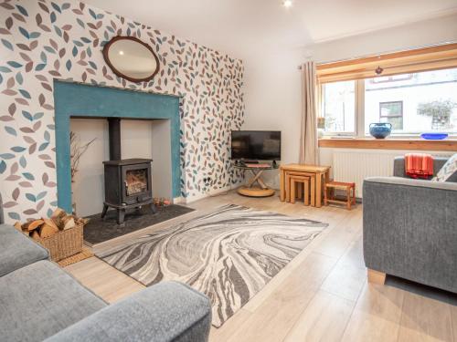 a living room with a fireplace and a tv at Isla's Cottage in Nairn