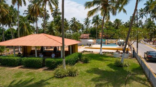 a resort with palm trees and a building at Pousada Plenamar in Maragogi