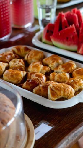 two plates of pastries on a table with watermelon at Pousada Plenamar in Maragogi