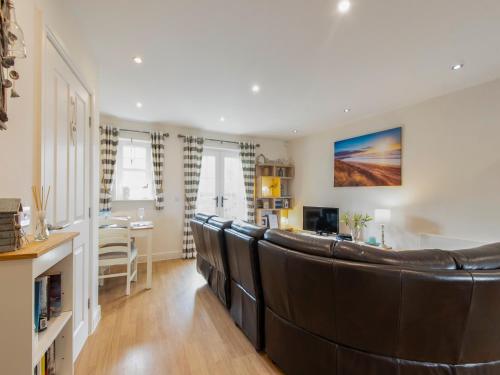 a living room with a large leather couch at Harbour Retreat in Garlieston