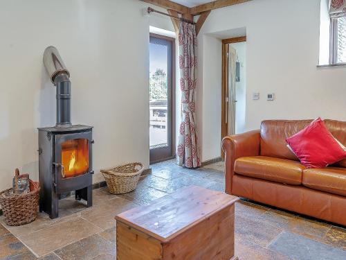 a living room with a couch and a wood stove at Y Llaethdy - Uk49916 in Penclawdd
