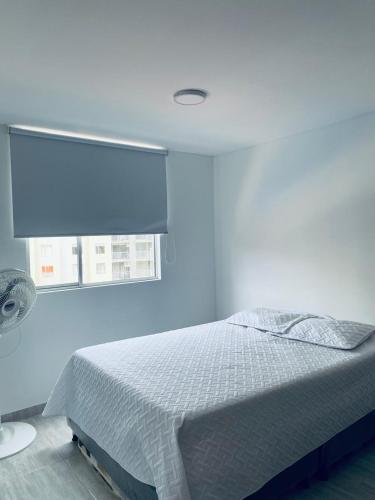 a blue bedroom with a bed and a window at Apartamiento Ricaurte -Colombia in Girardot