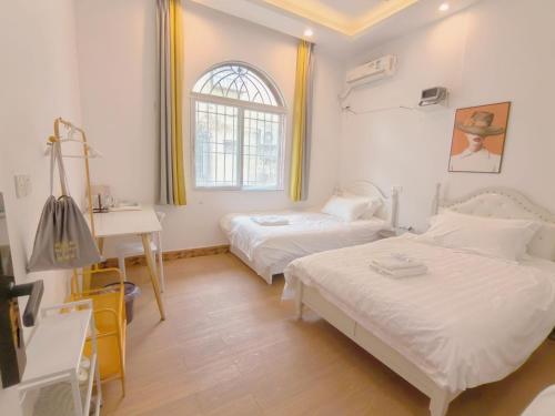 a bedroom with two beds and a sink and a window at 厦门哈哈虎客栈 in Xiamen