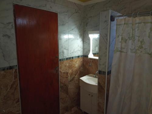 a bathroom with a shower curtain and a sink at Alojamiento ferchis in San Clemente del Tuyú