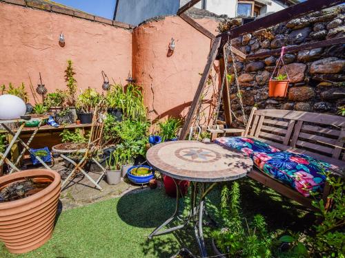 patio ze stołem i krzesłem na dziedzińcu w obiekcie Rainbow Cottage w mieście Vickerstown