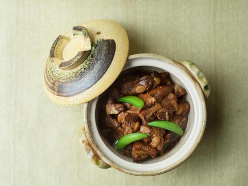 a bowl of food with mushrooms and green peppers at Mitsui Garden Hotel Kyobashi - Tokyo Station in Tokyo