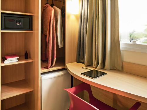 a desk in a closet with a window and a red chair at ibis Rio de Janeiro Parque Olimpico in Rio de Janeiro