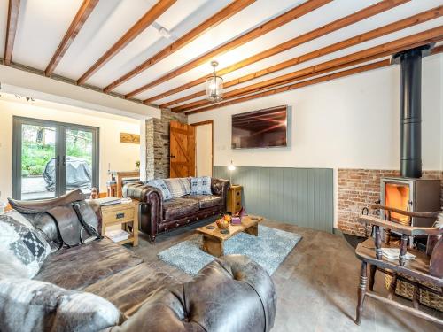 a living room with leather furniture and a fireplace at Shire - Uk49791 in Cribyn