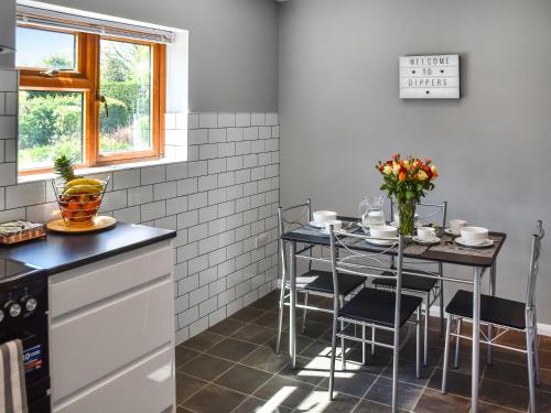 a kitchen with a table and chairs in a kitchen at Dippers in Smallburgh