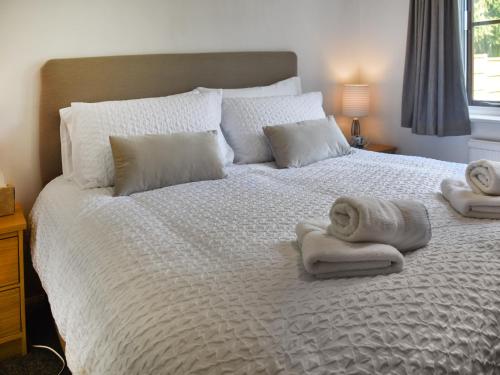 a bedroom with a bed with towels on it at Dippers in Smallburgh