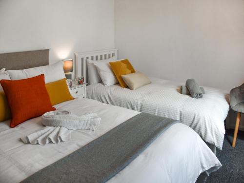 two beds with towels on them in a bedroom at Dippers in Smallburgh