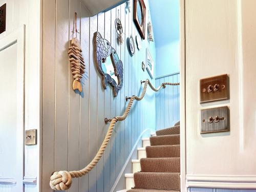 a hallway with a staircase with nautical items on the wall at Coast Away in Fraserburgh