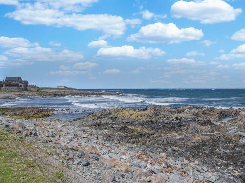 a beach with rocks and the ocean on a cloudy day at Coast Away in Fraserburgh