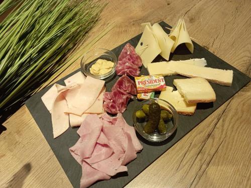 a plate of cheese and other foods on a table at ibis les Etangs des Moines in Fourmies