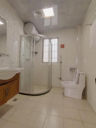 a bathroom with a shower and a toilet and a sink at 厦门哈哈虎客栈 in Xiamen