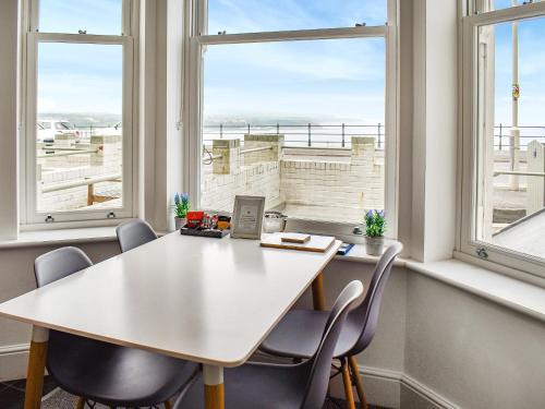 an office with a table and chairs and windows at Headland View in Scarborough