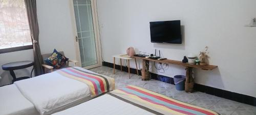 a bedroom with a bed and a television on the wall at Peace Inn The Leshan Giant Buddha Branch in Leshan