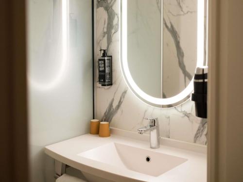 a bathroom with a sink and a mirror at IBIS Port de plaisance in Caen