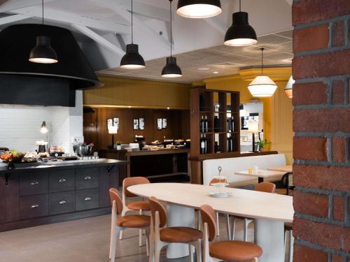 a kitchen with a table and chairs and a counter at IBIS Port de plaisance in Caen