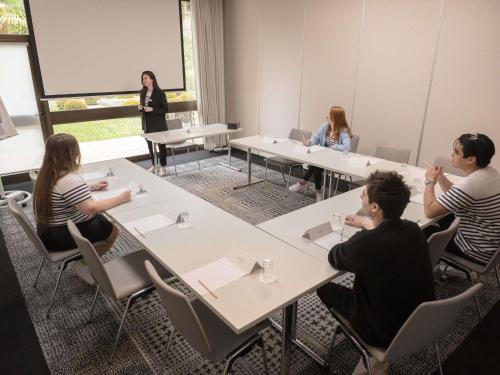 a group of people sitting at tables in a room at IBIS Port de plaisance in Caen