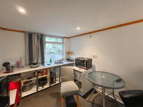 a kitchen with a table and a table and a table and a microwave at Seaside in Peacehaven
