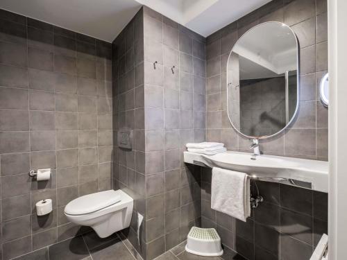 a bathroom with a toilet and a sink and a mirror at ibis Warszawa Centrum in Warsaw