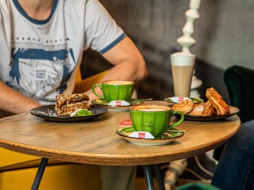 a table with plates of food and cups of coffee at ibis Warszawa Centrum in Warsaw