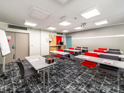 a conference room with tables and red chairs at ibis Warszawa Centrum in Warsaw