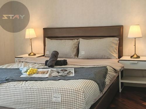 un lit avec un plateau de nourriture et des chaussures dessus dans l'établissement Grand Medini Couple Stylish Netflix 100mbps BySTAY, à Nusajaya