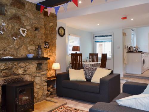 a living room with a couch and a stone wall at Horseshoe Cottage in Porchfield