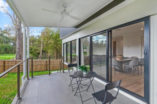 a screened porch with a table and chairs at CASSA AURA PLACE - Modern 4BR Homes in Brisbane