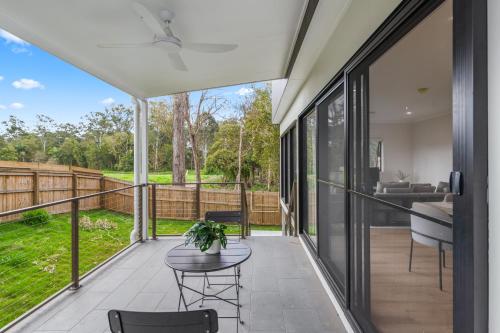 a screened porch with a table and chairs and a couch at CASSA AURA PLACE - Modern 4BR Homes in Brisbane