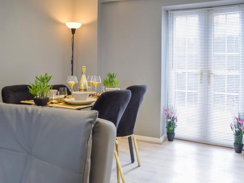 a dining room table with chairs and wine glasses at Apartment 3 - Uk50137 in Stoke on Trent