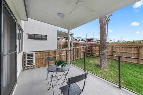 a balcony with a table and chairs and a tree at CASSA AURA PLACE - Modern 4BR Homes in Brisbane