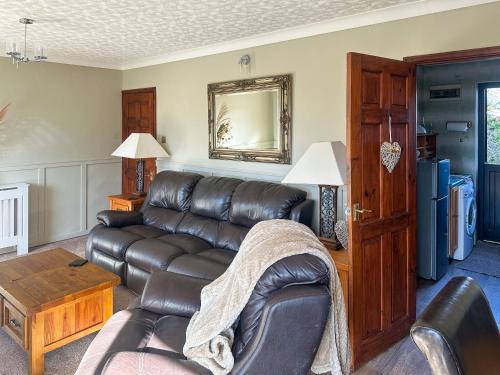 Una sala de estar con un sofá de cuero y una mesa. en Leanda Lodge, en Belton