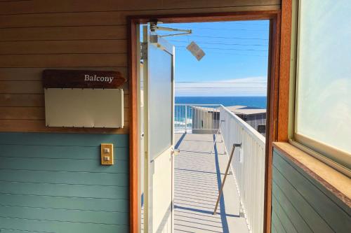 a door to a balcony with a view of the ocean at 海の見える高台に佇む隠れ家宿 #貸別荘 #一棟貸切 #グループや家族旅行におすすめ #テラスで海を眺めながらBBQ #屋内でもBBQ可 #BBQグリル付 #大洗 #鉾田 #umibe in Hokota