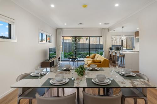 a kitchen and living room with a table and chairs at CASSA AURA PLACE - Modern 4BR Homes in Brisbane