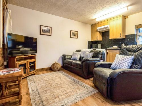 a living room with couches and a flat screen tv at Yarlington Mill in Ledbury