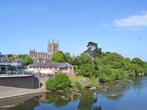 a view of a river with a castle in the background at Yarlington Mill in Ledbury