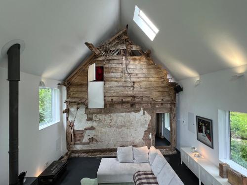 a living room with a white couch and a brick wall at Croft Lodge Studio in Leominster