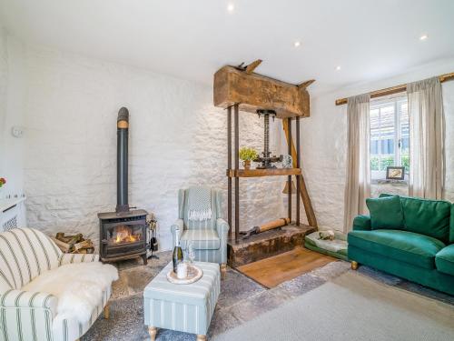 a living room with a couch and a fireplace at The Cider House in West Pennard