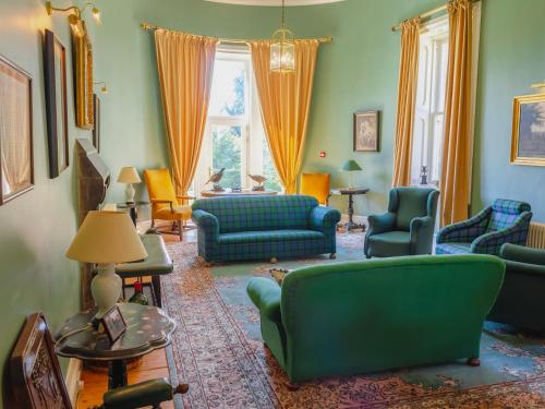 a living room with green furniture and orange curtains at Dalnaglar Castle - Uk7072 in Cray