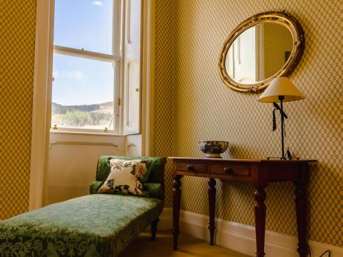 a room with a chair and a table and a mirror at Dalnaglar Castle - Uk7072 in Cray