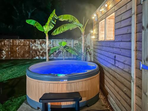 a hot tub in a backyard with a plant in it at Dippers in Smallburgh