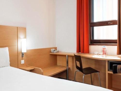 a hotel room with a bed and a desk and a kitchen at Ibis Astana in Astana