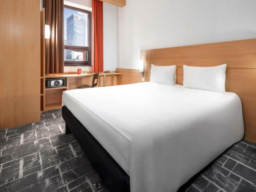 a large white bed in a hotel room at Ibis Astana in Astana