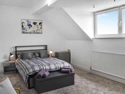 a white bedroom with a bed and a window at Ocean Breeze in Heysham