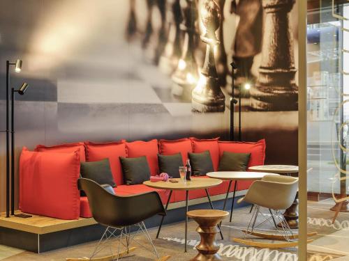 a restaurant with a red couch and a table at Ibis Berlin Hauptbahnhof in Berlin
